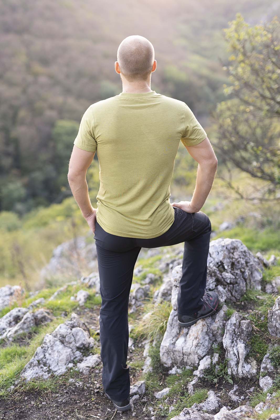 Ein Mann steht aufm Berg. Hat ein kurzarm Tshirt aus Merino der Marke KALLYS an.